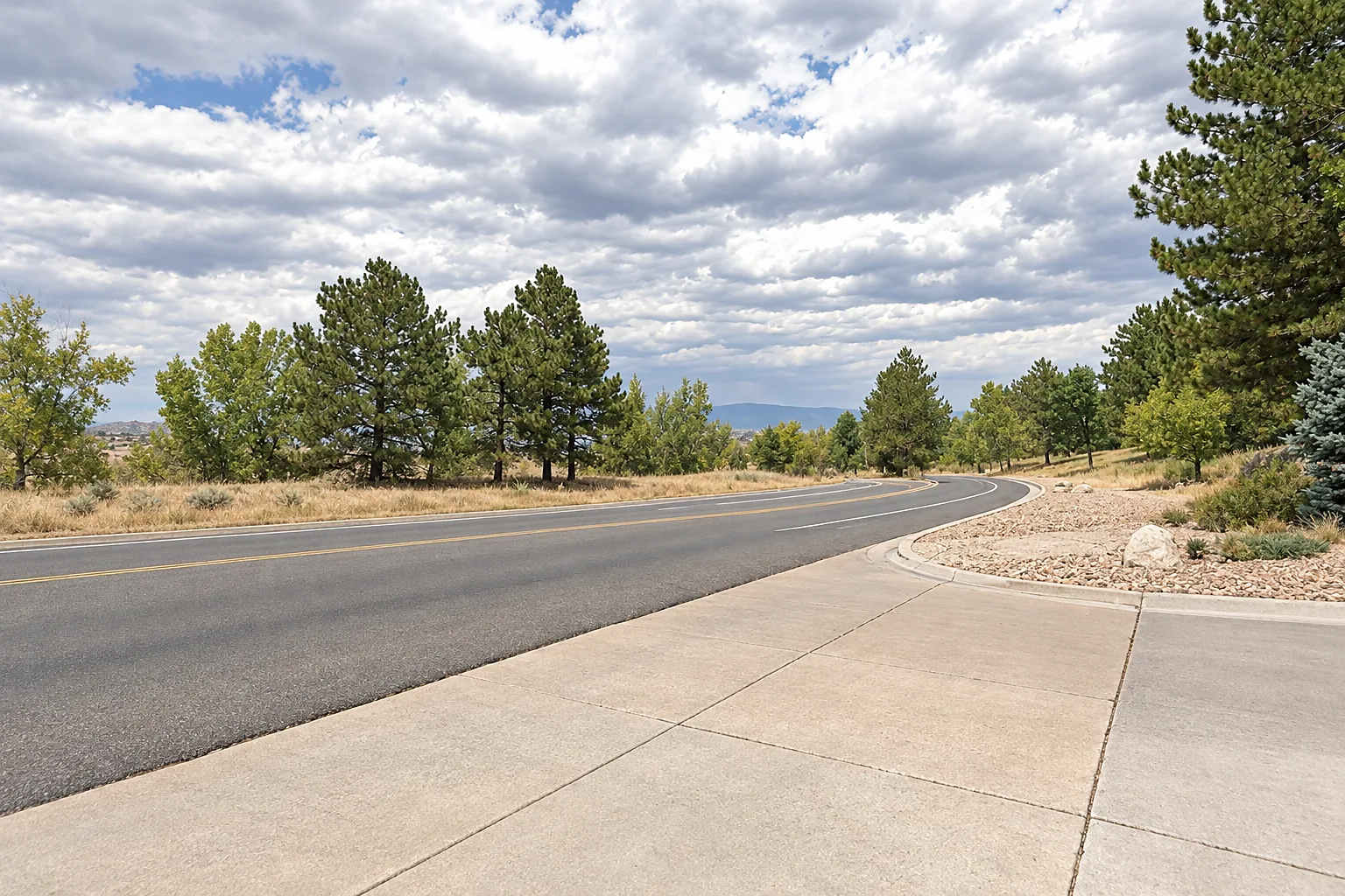 Open high-prairie land with ponderosa pines along a suburban parkway in Castle Rock, Colorado